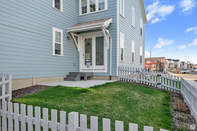 property entrance featuring a yard, fence, and a residential view