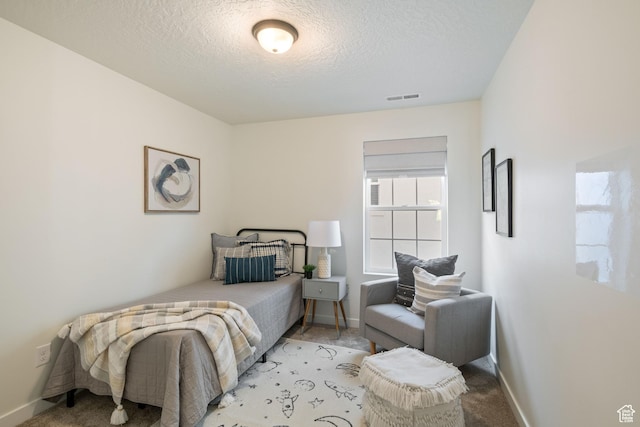 bedroom featuring visible vents, baseboards, carpet, and a textured ceiling
