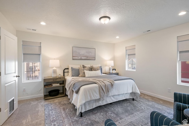 carpeted bedroom with recessed lighting, visible vents, baseboards, and a textured ceiling