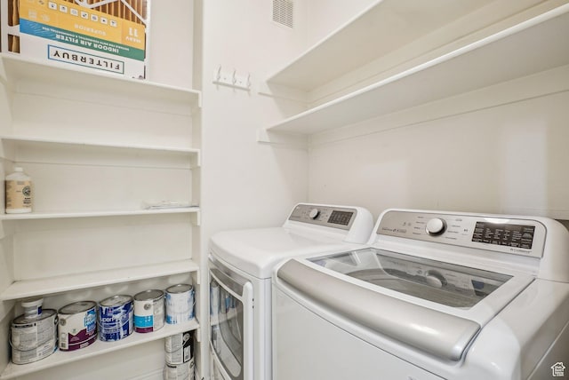 laundry room with laundry area, washing machine and clothes dryer, and visible vents