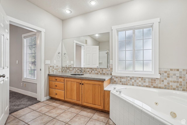 full bath featuring baseboards, a shower stall, a jetted tub, vanity, and tile patterned floors