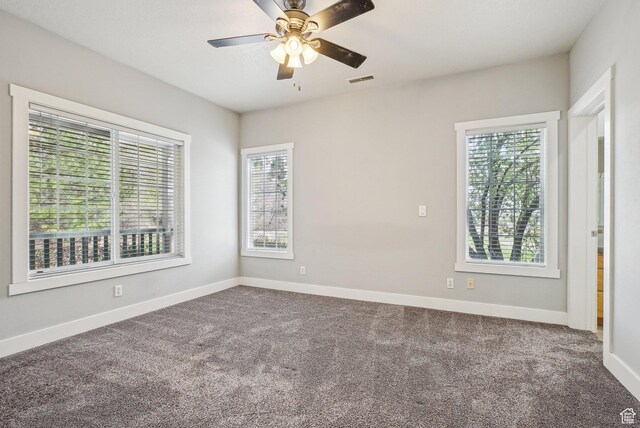 spare room with ceiling fan, baseboards, visible vents, and carpet floors