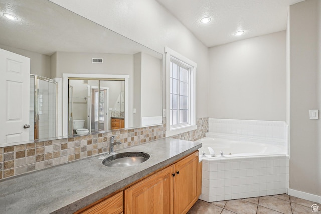 bathroom with visible vents, tile patterned flooring, vanity, a stall shower, and a garden tub