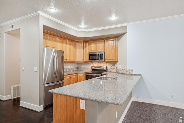 kitchen with a peninsula, visible vents, appliances with stainless steel finishes, light stone counters, and a sink