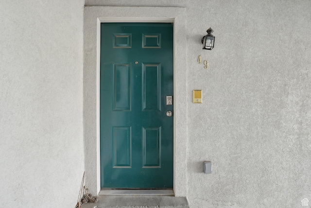 property entrance featuring stucco siding and elevator