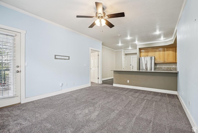 unfurnished living room with ceiling fan, dark colored carpet, ornamental molding, and baseboards