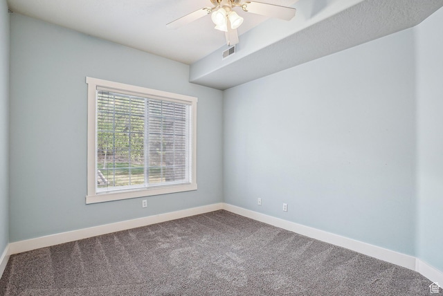 empty room with carpet flooring, visible vents, baseboards, and a ceiling fan