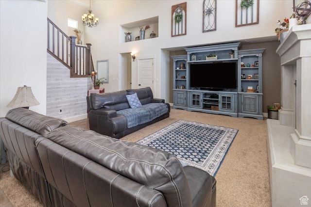 carpeted living room featuring a notable chandelier, a high ceiling, and baseboards