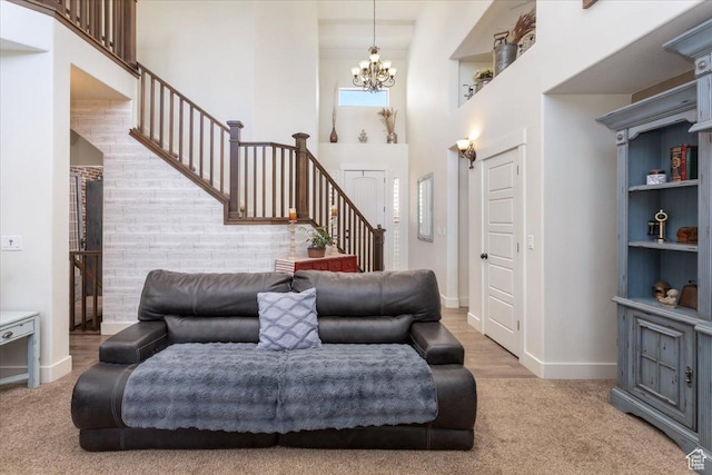 carpeted living room featuring stairs, a high ceiling, baseboards, and an inviting chandelier