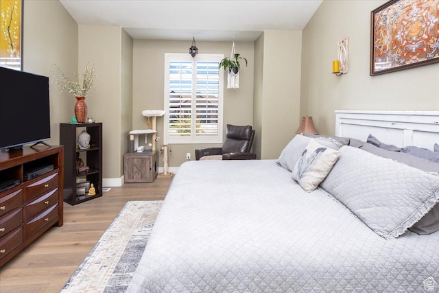 bedroom with light wood-style flooring and baseboards