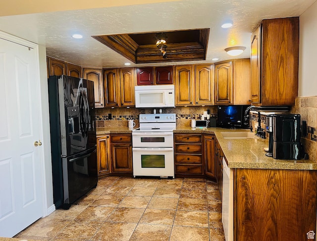 8366 S Cobble Cir W, West Jordan, UT 84081 - kitchen with a sink, brown cabinets, white appliances, a tray ceiling, and backsplash