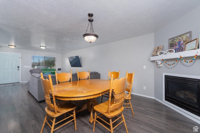 583 E 2680 S, Vernal, UT 84078 - dining area featuring a glass covered fireplace, a textured ceiling, baseboards, and wood finished floors