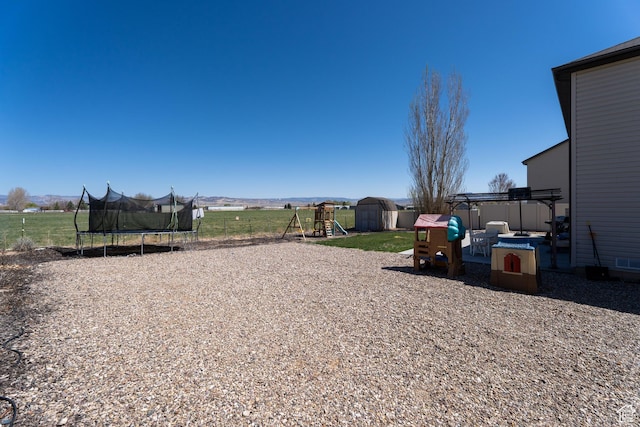 583 E 2680 S, Vernal, UT 84078 - view of yard featuring a trampoline, an outdoor structure, fence, a playground, and a storage unit