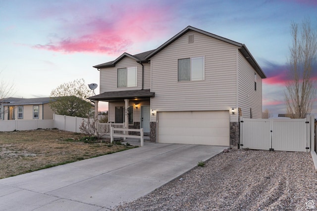 583 E 2680 S, Vernal, UT 84078 - traditional-style house featuring a gate, stone siding, an attached garage, fence, and covered porch