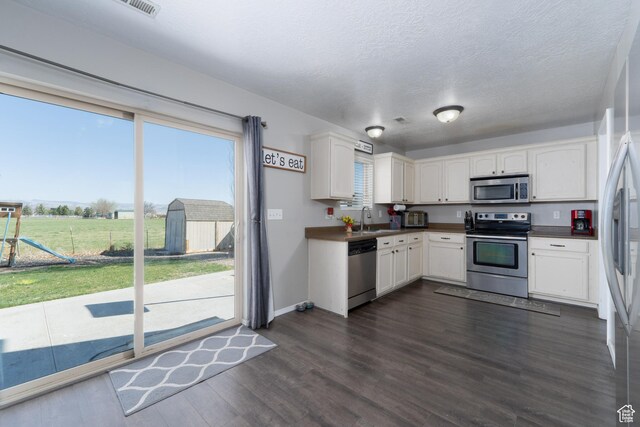 583 E 2680 S, Vernal, UT 84078 - kitchen with white cabinets, dark countertops, a sink, and appliances with stainless steel finishes