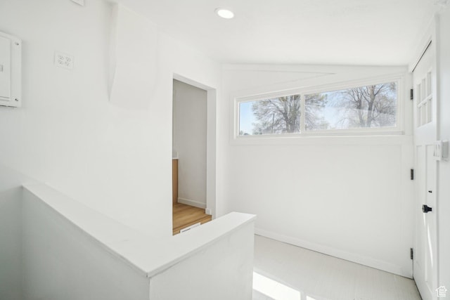 hall with baseboards, recessed lighting, light floors, and lofted ceiling