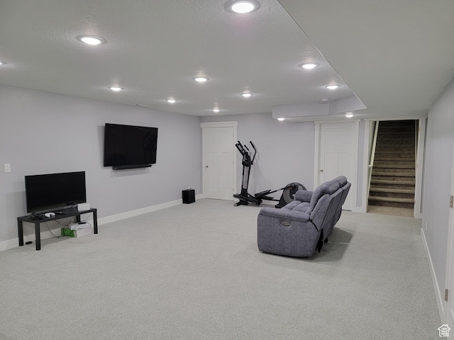 exercise room with recessed lighting, baseboards, light colored carpet, and a textured ceiling