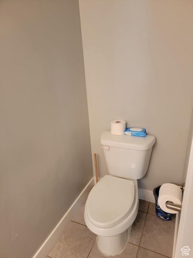 bathroom with tile patterned floors, baseboards, and toilet