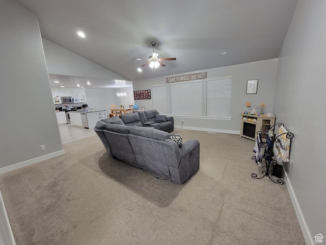 living area with baseboards, a ceiling fan, light carpet, and lofted ceiling