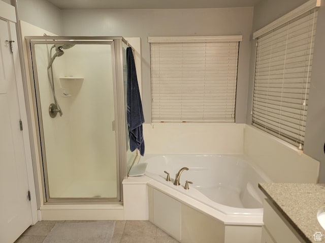 bathroom with tile patterned flooring, a shower stall, vanity, and a garden tub