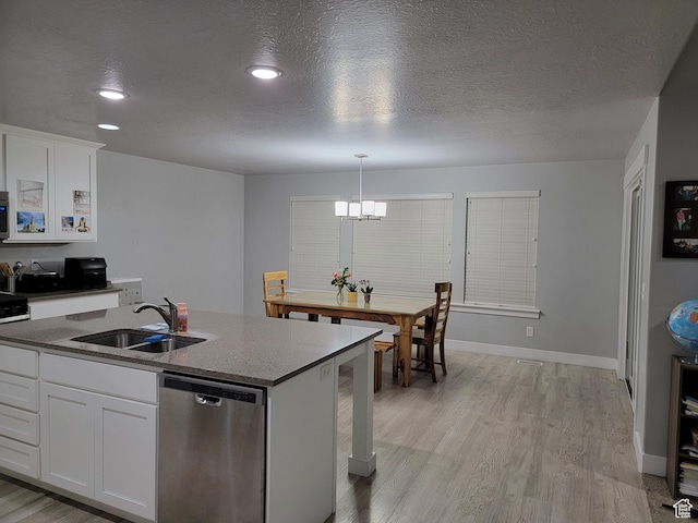 kitchen with a sink, appliances with stainless steel finishes, light wood-style floors, and white cabinetry