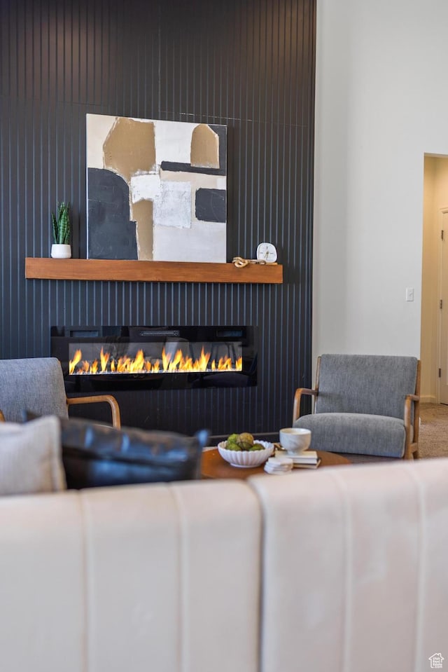 living area with carpet flooring and a glass covered fireplace