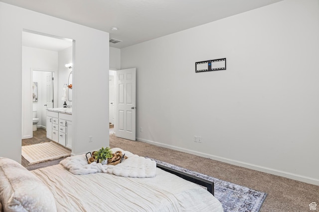 bedroom featuring visible vents, baseboards, ensuite bath, and light carpet