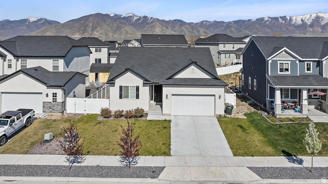 view of front facade featuring an attached garage, a residential view, stucco siding, and fence