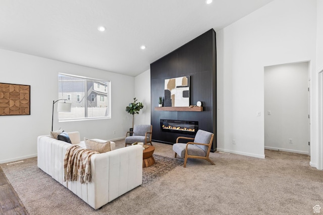 carpeted living area featuring recessed lighting, a large fireplace, and baseboards