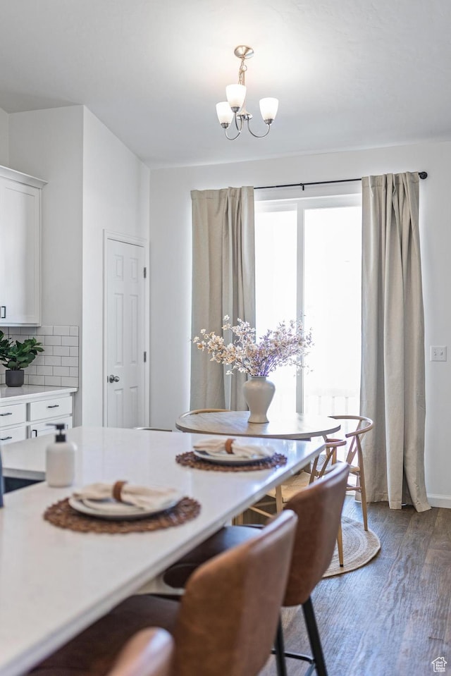 dining area with a chandelier and wood finished floors