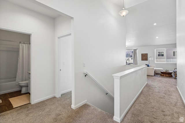 corridor featuring carpet floors, baseboards, an upstairs landing, and recessed lighting
