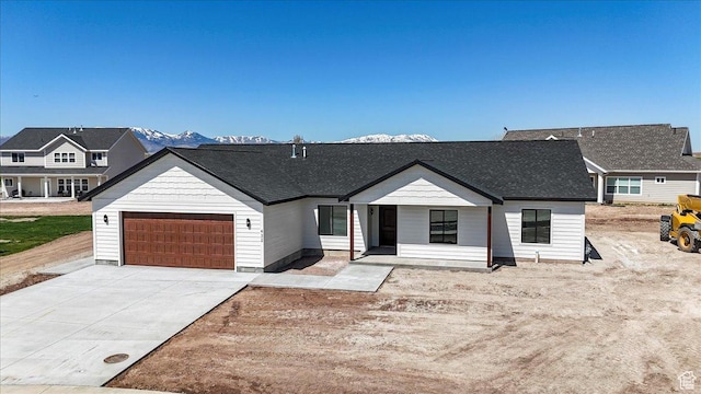 modern farmhouse style home featuring an attached garage, driveway, and roof with shingles