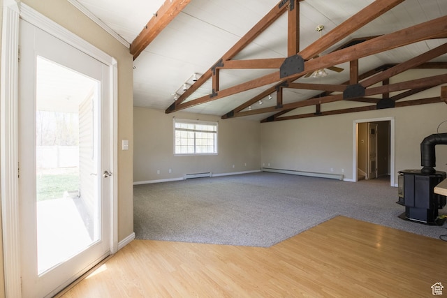 1370 S 1900 E, Vernal, UT 84078 - unfurnished living room featuring a baseboard heating unit, baseboards, vaulted ceiling with beams, and a wood stove