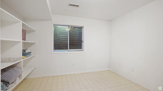 spare room with visible vents, tile patterned floors, and baseboards