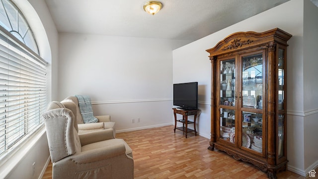 sitting room with light wood-type flooring and baseboards