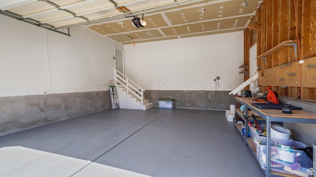 garage with a garage door opener and a workshop area