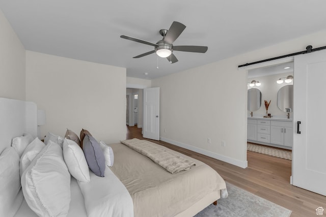 1958 E Janet Kay Ln, Holladay, UT 84121 - bedroom featuring baseboards, a barn door, ceiling fan, light wood-type flooring, and ensuite bath