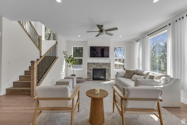 1958 E Janet Kay Ln, Holladay, UT 84121 - living area featuring light wood-type flooring, a ceiling fan, a stone fireplace, and stairs