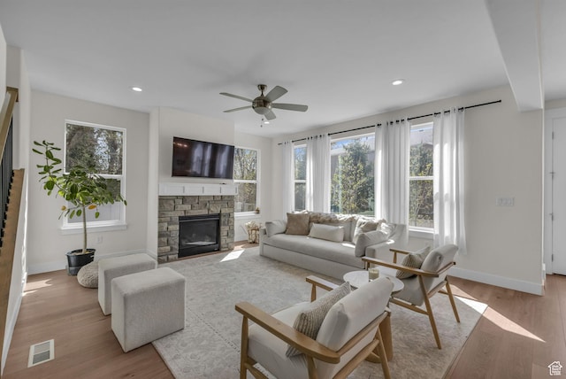 1958 E Janet Kay Ln, Holladay, UT 84121 - living area with visible vents, baseboards, a stone fireplace, ceiling fan, and light wood-type flooring