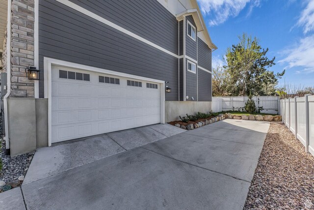 1958 E Janet Kay Ln, Holladay, UT 84121 - view of property exterior featuring fence, stone siding, a garage, and concrete driveway