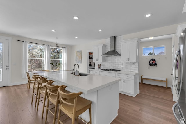 1958 E Janet Kay Ln, Holladay, UT 84121 - kitchen with freestanding refrigerator, a center island with sink, wall chimney exhaust hood, gas stovetop, and a sink