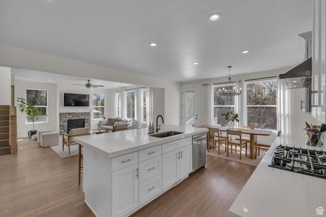 1958 E Janet Kay Ln, Holladay, UT 84121 - kitchen with a fireplace, black gas cooktop, dishwasher, ceiling fan with notable chandelier, and a sink