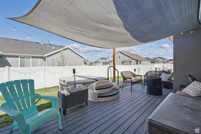 deck with a residential view, a fenced backyard, and a fire pit