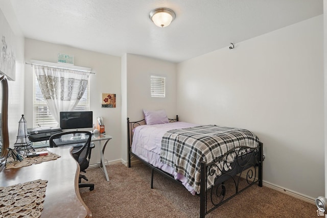 carpeted bedroom featuring baseboards and multiple windows