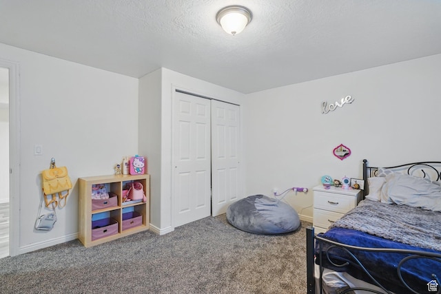 carpeted bedroom with a closet, baseboards, and a textured ceiling