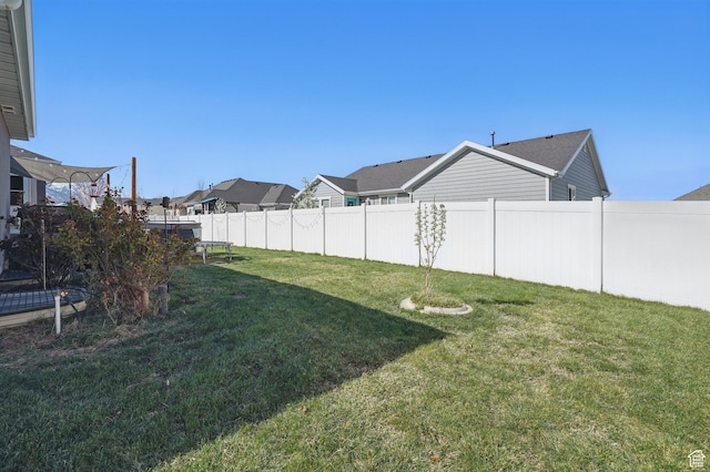 view of yard with a residential view, a trampoline, and fence