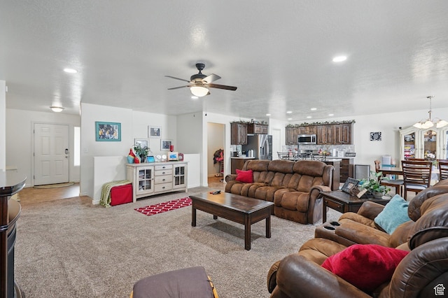 living room with light carpet, recessed lighting, ceiling fan with notable chandelier, and baseboards