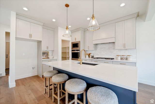 kitchen with baseboards, a sink, appliances with stainless steel finishes, and tasteful backsplash