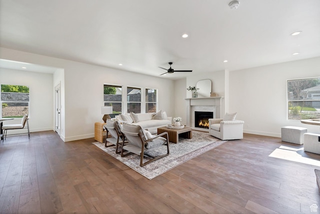 living area with ceiling fan, a lit fireplace, recessed lighting, and hardwood / wood-style floors