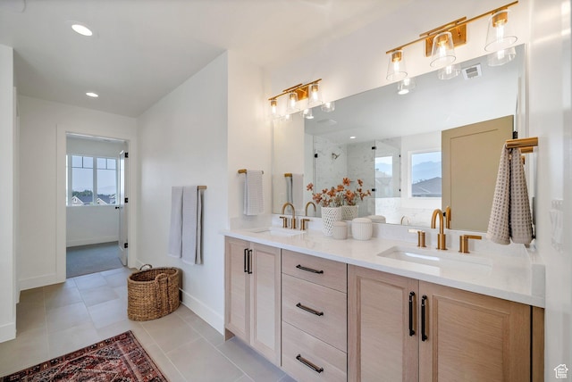 bathroom featuring a sink, a shower with shower door, and a healthy amount of sunlight